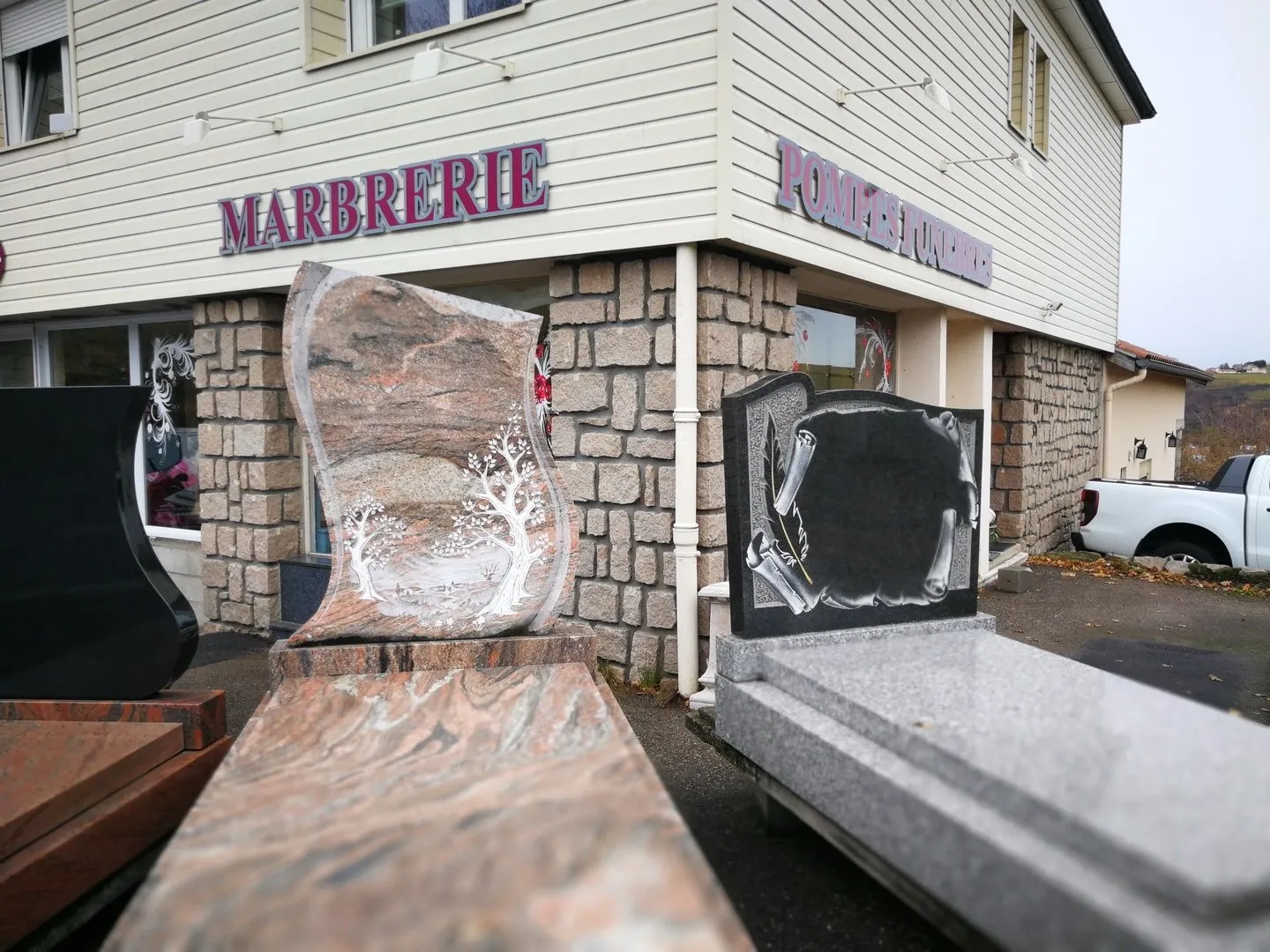 Devanture de l'agence de marbrerie et pompes funèbres avec présentation de monuments funéraires